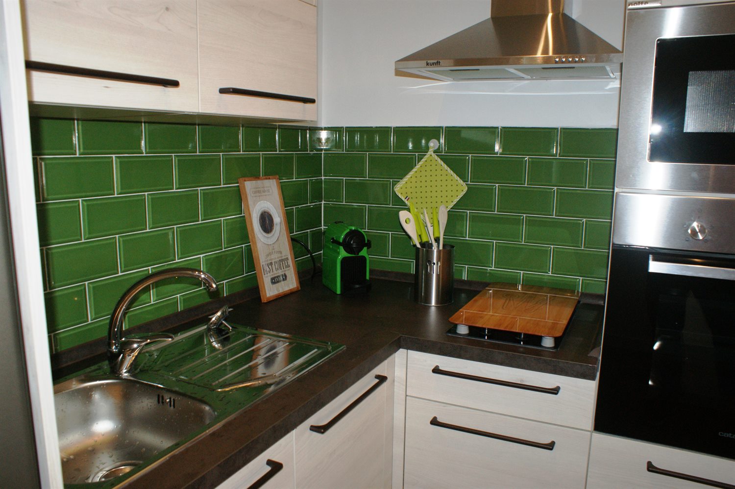 Cozinha compacta com revestimento verde e bancada escura
